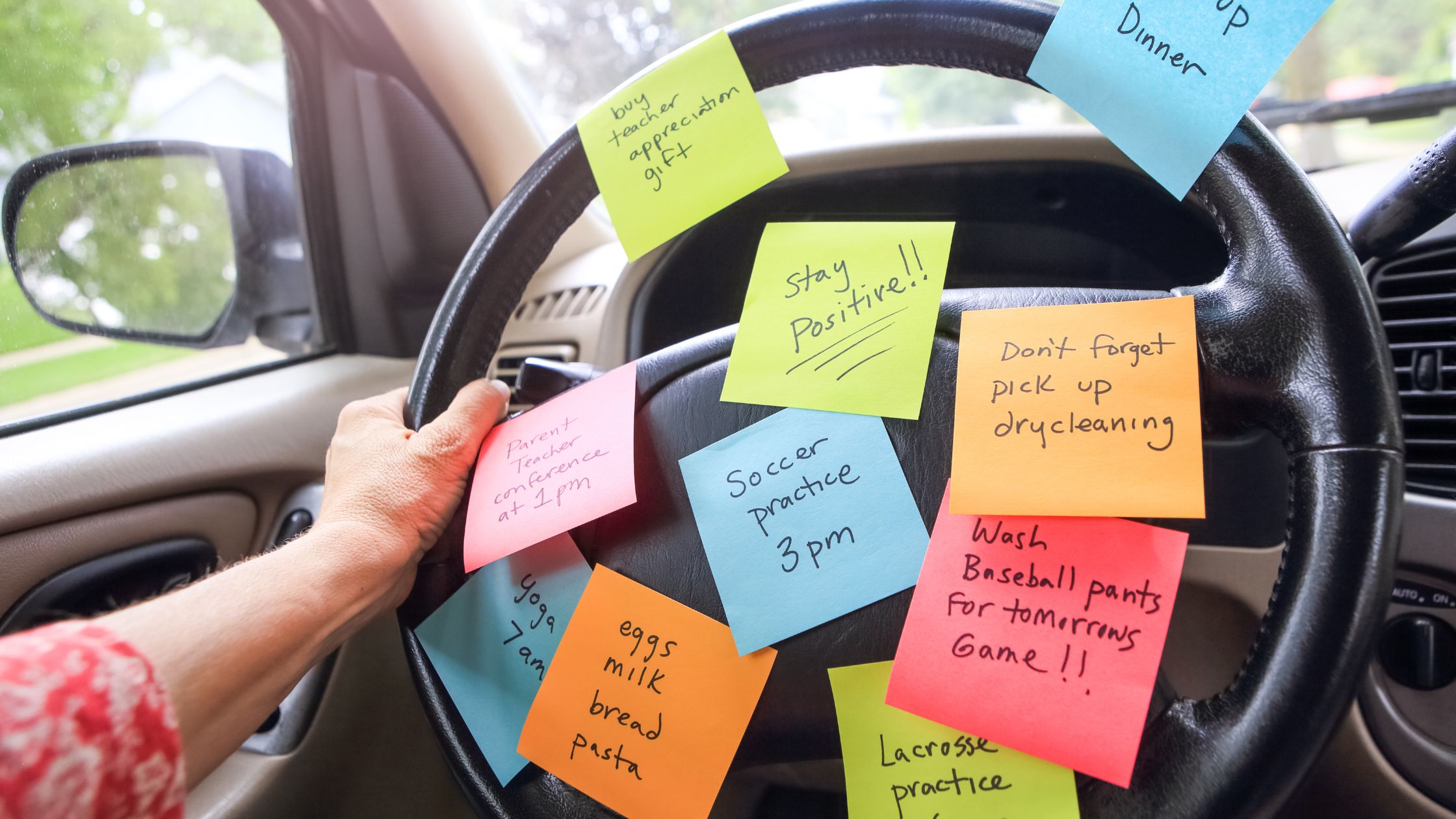 woman driving van with sticky notes todo tasks all over steering wheel